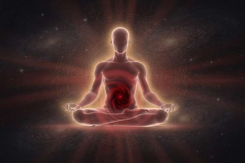 Frau in roter Kleidung führt eine stabile Yoga-Pose aus, um das Wurzelchakra zu aktivieren und innere Erdung zu fördern.